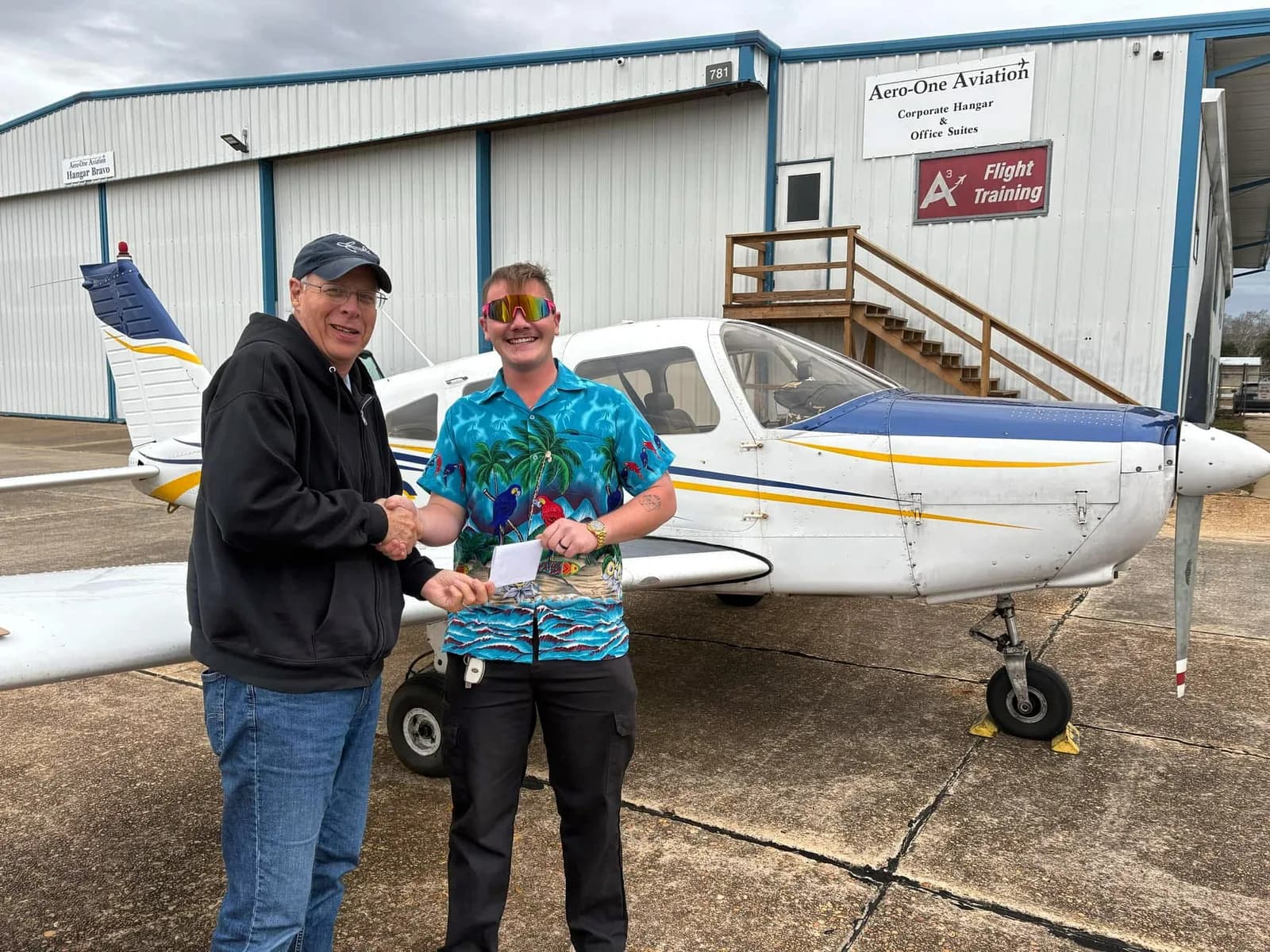 Instructor congratulating a student outside the hangar after a checkride at 71J, Ozark AL