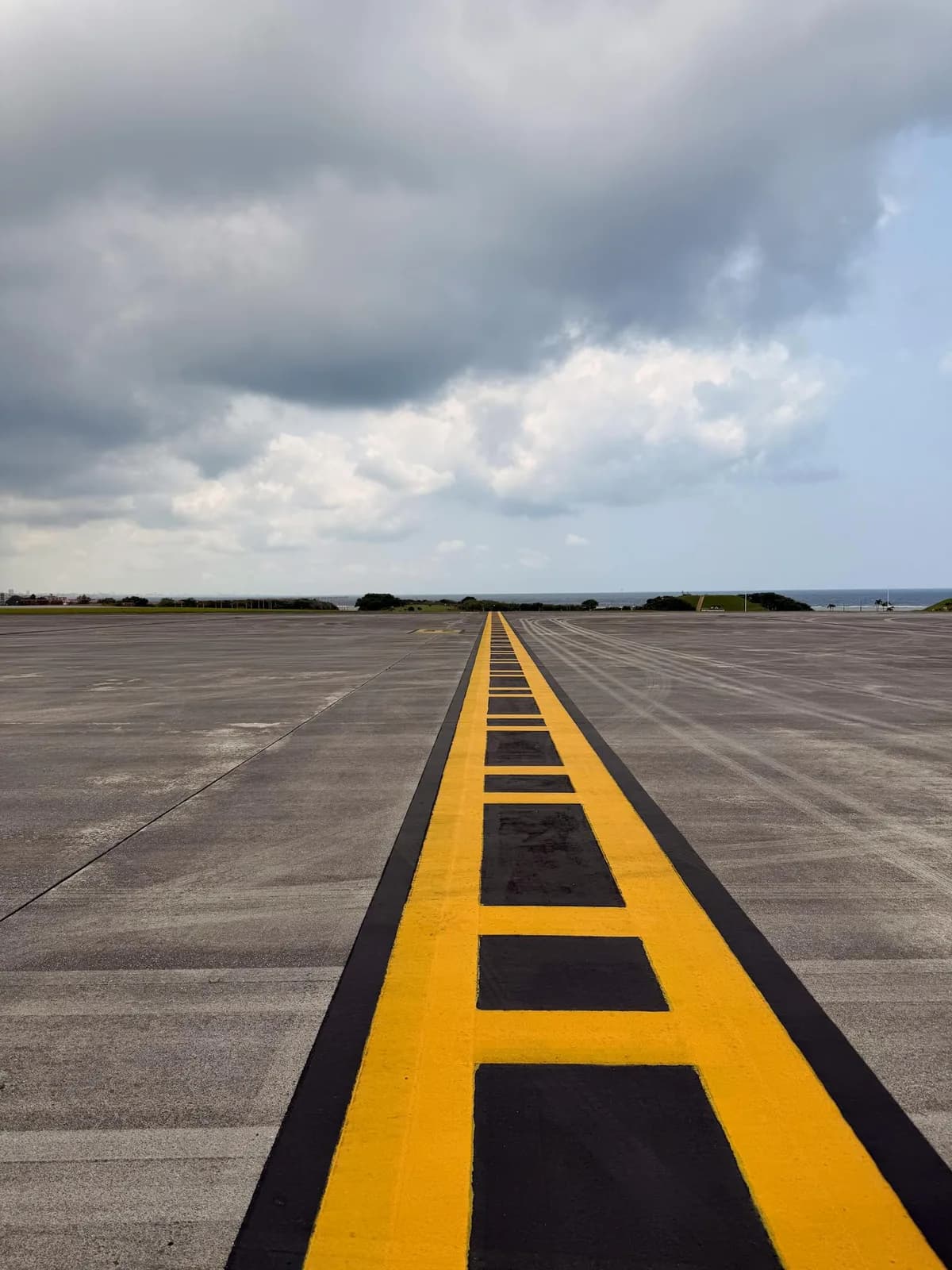 Runway centerline markings stretching into the distance under a cloudy sky